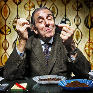 Fotografia di Giovanni Filicori che osserva compiaciuto un chicco di caffè.