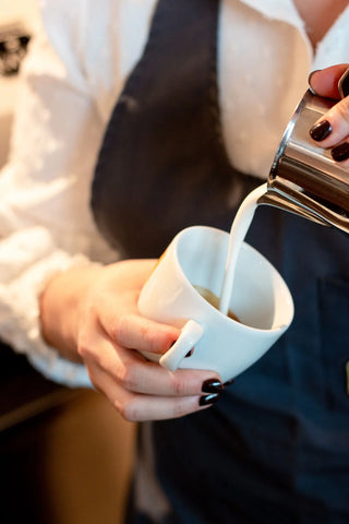 Dettaglio del modo di versare il latte nella preparazione del cappuccino.