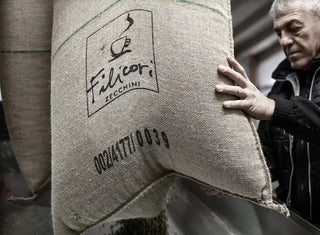 Fotografia di un sacco di caffè verde con marchio Filicori Zecchini, nel momento in cui viene aperto per la tostatura.