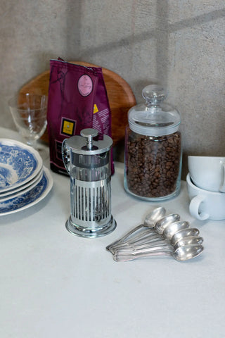 Immagine di sapore con caffettiera french press, sacchetto caffè in chicchi Filicori Zecchini Guatemala e varie suppellettili per la tavola.