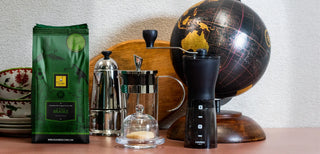 Sac de grains de café Grand Cru Brésil, avec des cafetières Moka et French Press et un moulin.
