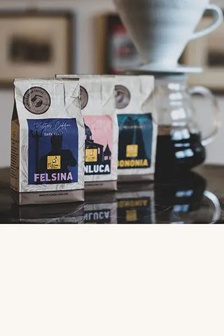 Three single-portion 34g bags of ground coffee for one filter - V60 coffee pot in the background.